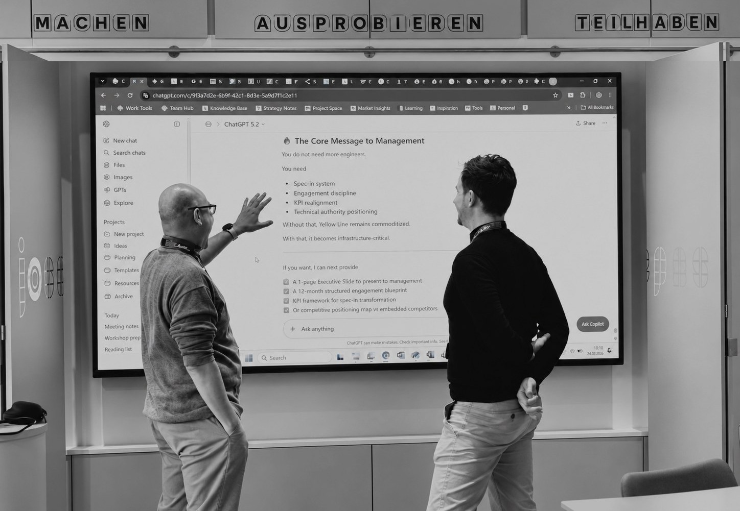 Zwei Personen diskutieren im Strategy Lab vor einem Bildschirm